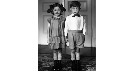 Black and white image of a boy and girl holding hands.