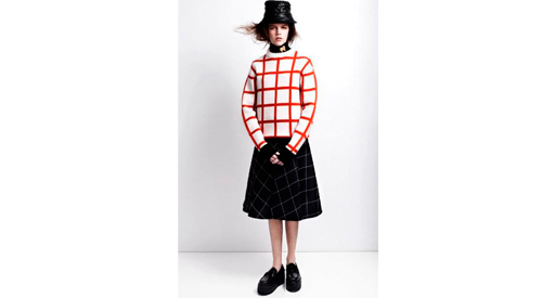 Woman in black hat and skirt with a red and white grid shirt.