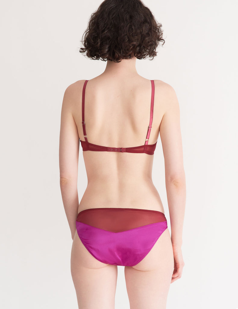 a model in the beatrice bralette and aaron panty in amaranth magenta and red