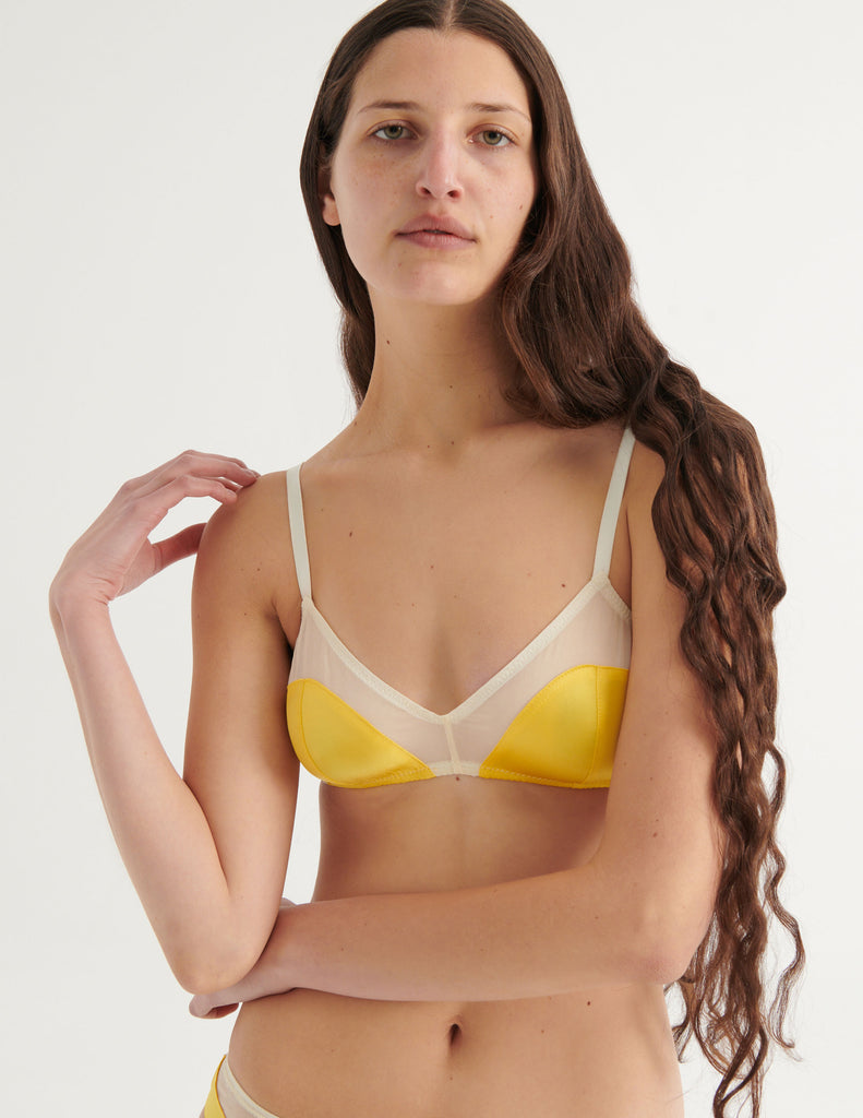 a model with her hand up in the beatrice bralette in yellow sun