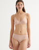 A model wearing the briar bralette in light pink nude cotton