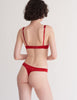 A model wearing the Grier Thong in red silk