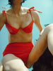 a model in the myriam bikini top in poppy red and the mallory hipster