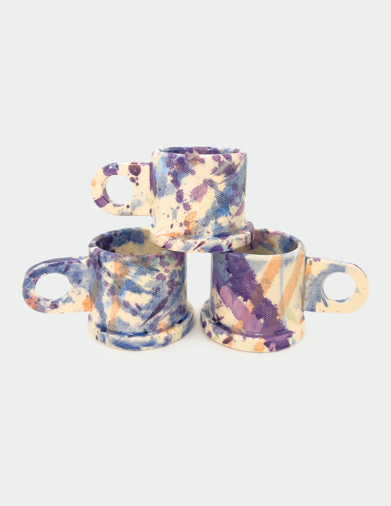 image of 3 handmade splatter espresso mugs made by peter shire in purple and peach.