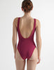 a model from the back in a red brown one piece luna swimsuit