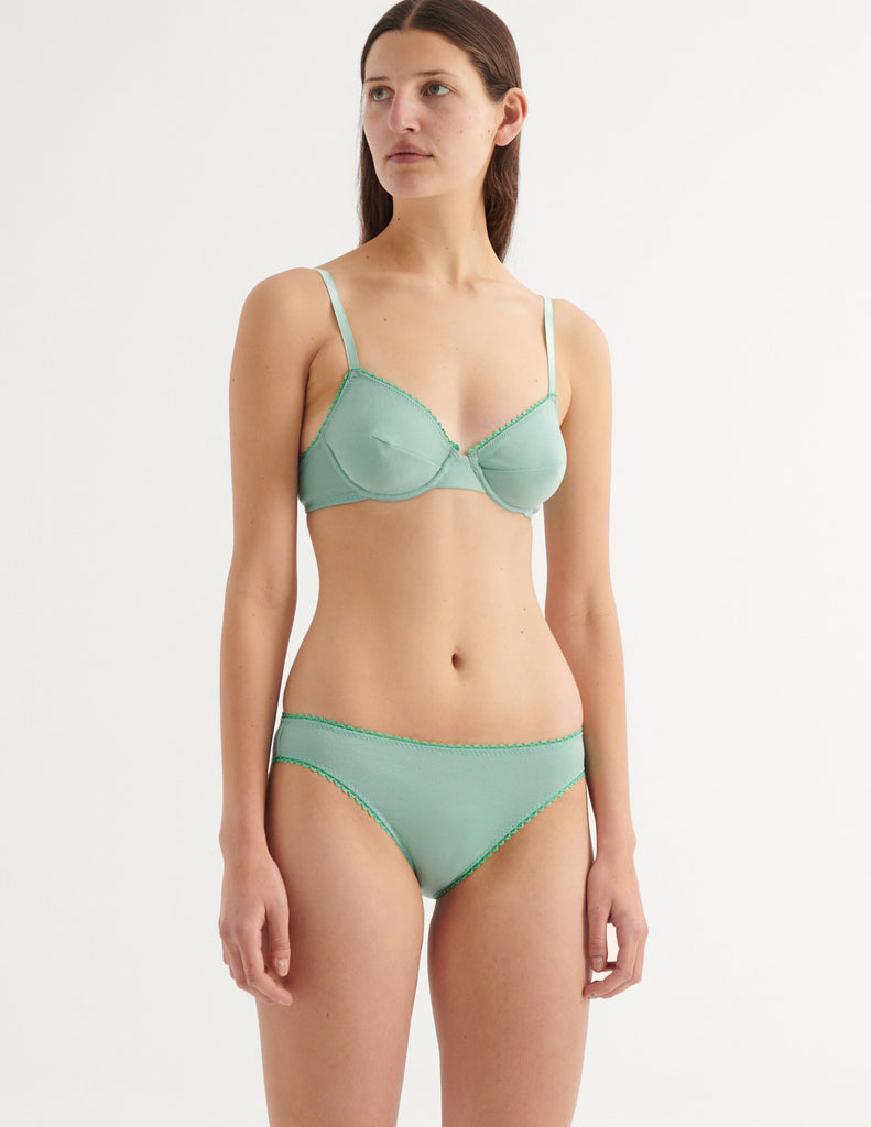 a model in the isabella panty in sage and sofia underwire bra in sage green