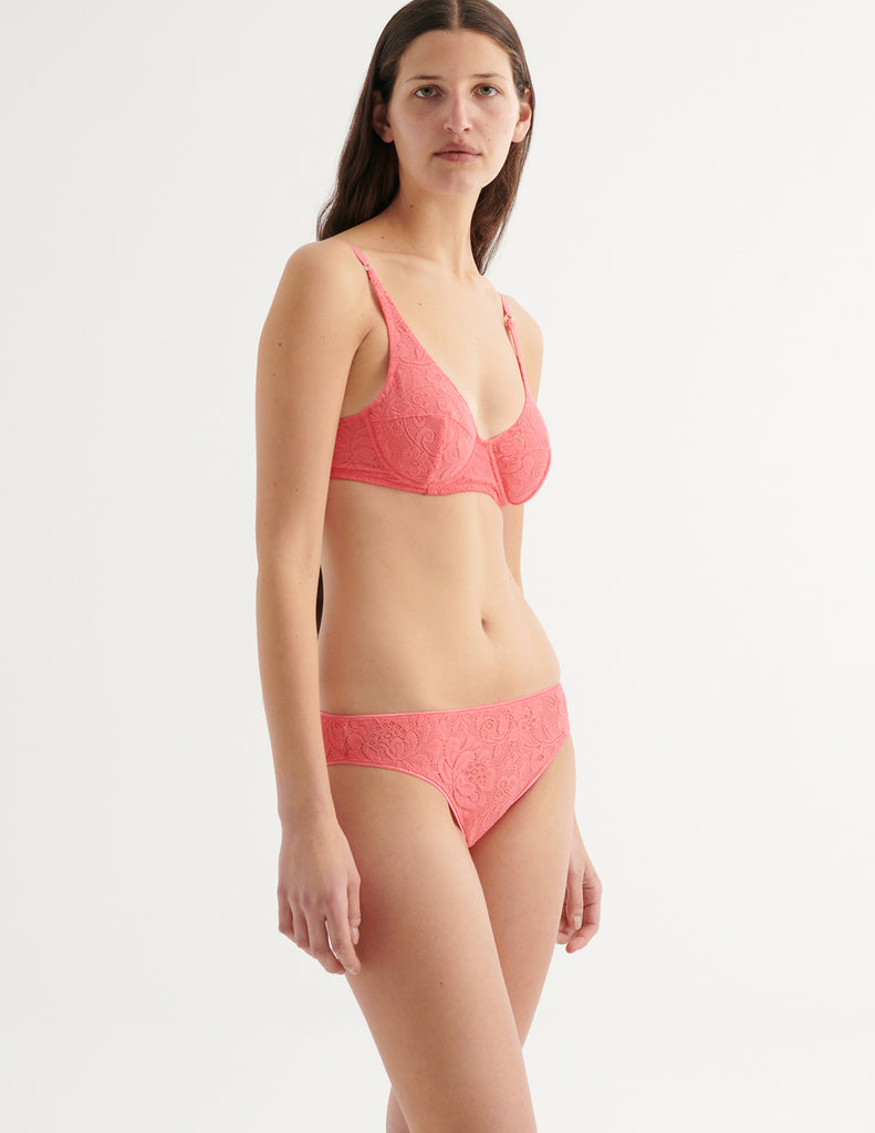 a three-quarters image of a model in the waverly underwire bra and tris panty in prima pink