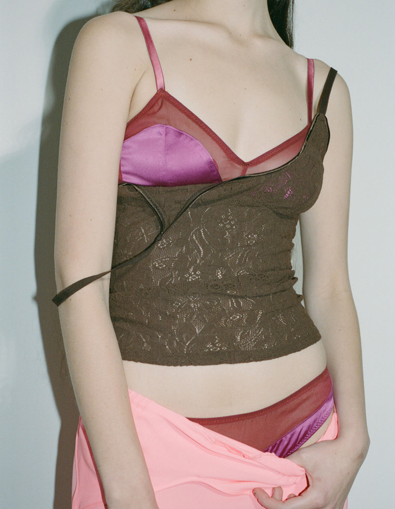 a model wearing the beatrice bralette and georgia cami in pink silk and brown lace