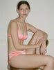 a model wearing the gita bra and gal hip hugger in pink silk