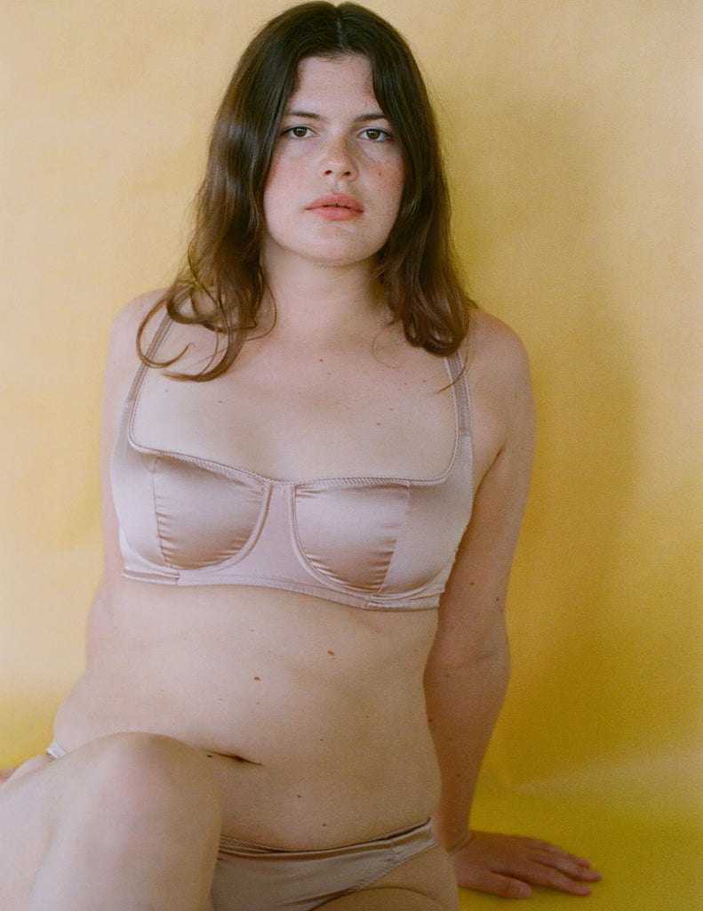 a model wearing the gita bra in light pink silk