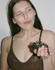 a model wearing the waverly bra in brown lace eating a cake